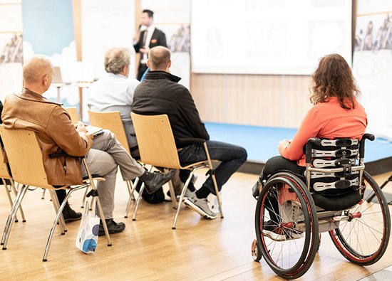 person in a wheelchair watching a presentation