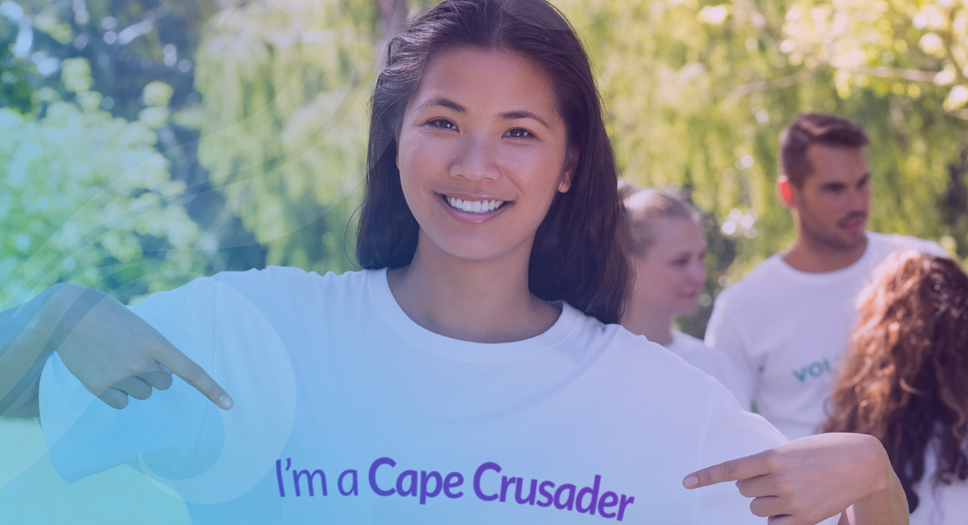 girl pointing at words on her shirt that say I'm a Cape Crusader