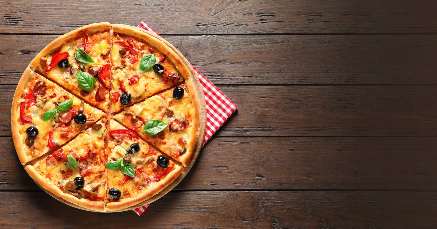 Delicious pizza lying on a wooden table.