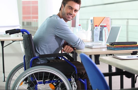 man in wheelchair sitting at a table